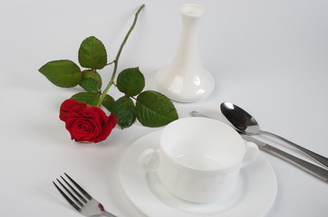 Wall Mural - Served table with white dishes, red rose on white background