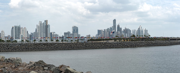 Wall Mural - panama city skyline, behind a quay wall with flags from different countries