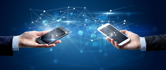 close up of two hands holding smartphones and sharing business data