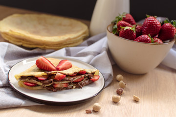 Wall Mural - crepes with strawberries and chocolate cream, black background