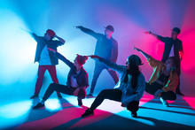 Group Of Diverse Young Hip-hop Dancers In Studio With Special Lighting Effects In Blue And Pink Colores