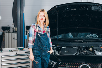 Wall Mural - awesome blond female mechanic in uniform posing at the camera. close up photo. copy space, interest, free time