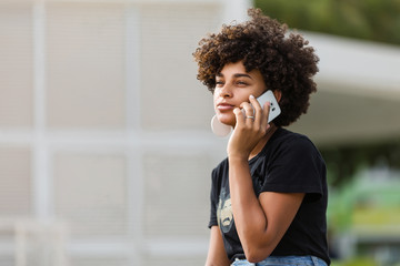 Outdoor portrait of a Young black African American young woman speaking on mobile phone