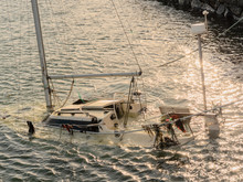 Partially Sinked Yacht By A Pier In A Port. Concept Disaster, Safety,