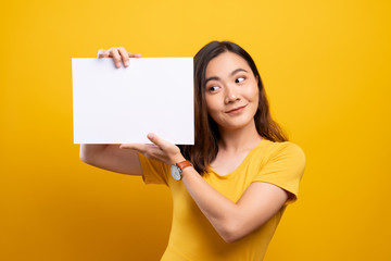 Woman showing paper copy space isolated over yellow background