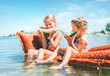 © Soloviova Liudmyla - Two little sisters sitting on innflatable mattrace and eating watermelon