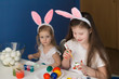 © erainbow - Girls paint easter eggs
