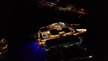 Aerial view of luxury yachts and night party in marina, people have a great fun during boat party during summer season and yacht week