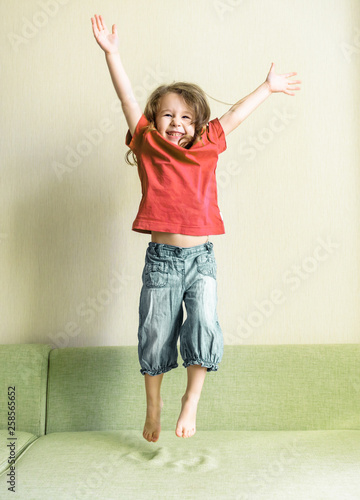 Funny Three Year Old Child Jumps On Couch Happy Little Girl