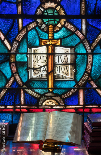 Fotografía Colored light from stained glass window in methodist church falls across open bi