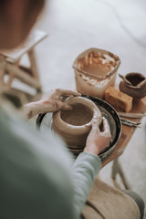 Wall Mural - Young woman making clay pot in pottery workshop