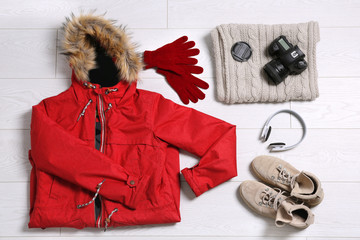 Wall Mural - Flat lay composition with warm clothes for winter vacation on wooden background