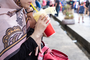 baby breastfeeding and sleeping in mother's hug. mother drink while baby breastfeeding.