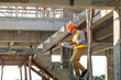 © phoderstock - Asian architect or engineer holding looking project blueprint papers and wear helmet at construction site. He walking on stairs.