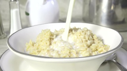 Wall Mural - Pouring milk onto a bowl of steamed rice