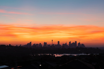 Sydney skyline with red orange sunset sky.