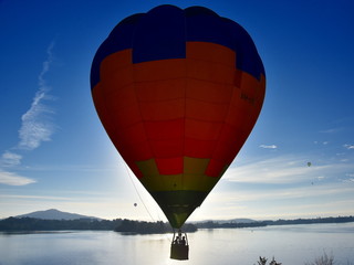 Wall Mural - Canberra, Australia - March 10, 2019. Hot air balloon flying in the air above Lake Burley Griffin, as part of the Balloon Spectacular Festival in Canberra.