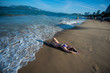© Михаил Решетников - A young woman in a seductive bikini lying on the beach. Girl lying on the sand by the ocean