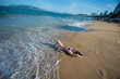 © Михаил Решетников - A young woman in a seductive bikini lying on the beach. Girl lying on the sand by the ocean