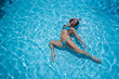 © Михаил Решетников - Over head rear view of an attractive young woman swimming under water and wearing in bikini