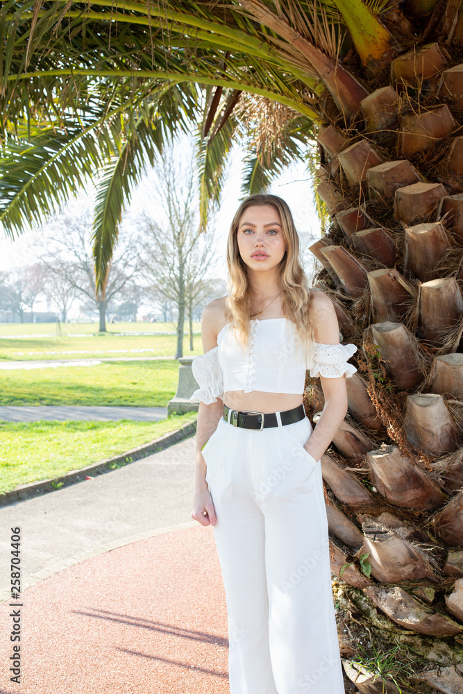 Teenage girl posing for a picture under a palm tree in the uk Stock ...