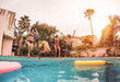 © Alessandro Biascioli - Group of happy friends jumping in pool at sunset time - Millennial young people having fun making party in exclusive resort tropical - Holidays, summer, vacation and youth lifestyle concept