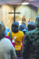 Wall Mural - Christian congregation worship God together, with cross with light rays in background