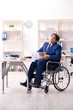 © Elnur - Young male employee in wheelchair working in the office