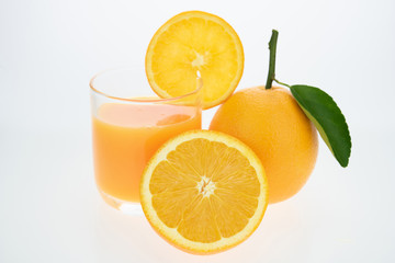 Orange juice and oranges with leaves