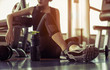 © Take Production - Relaxing after training.beautiful young woman looking away while sitting  at gym.young female at gym taking a break from workout.