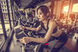 © Take Production - women working out in gym on the exercise bike.girl riding stationary bike at gym.