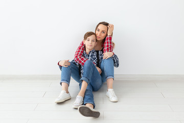 Wall Mural - Mothers day, children and family concept - Beautiful woman and her son on white background