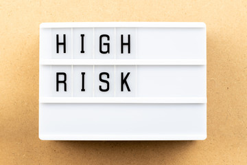 Sticker - Light box with word high risk on wood background