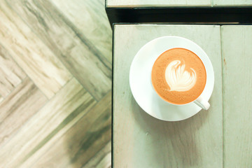 A cup of coffee at the top view on the background of wood table