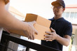 © wutzkoh - Close up of hands cargo staff are delivering cardboard boxes with parcels inside to the recipient's hand.