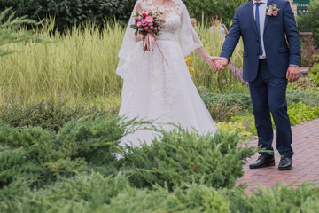 bride and groom walk together in the park