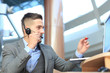 © ty - Smiling friendly handsome young male call centre operator.
