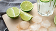 Limonka pokrojona na kawałki z kostkami lodu i szklanką do przygotowania napoju