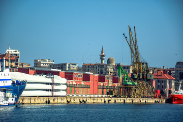 Colorful morning on the shore of the Black sea at Constanta Maritime Harbor, Romania. Old Town in the background.