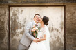 © Olha - beautiful wedding couple kissing near the old wall
