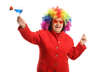 Poster - Cheerful senior woman with a colorful wig and a cocktail