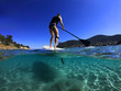 © aerial-drone - Underwater sea level photo of unidentified man on a SUP or Stand Up Paddle in turquoise crystal clear exotic mediterranean sandy beach