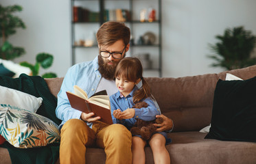 happy family. father reading a book to a child daughter at home   happy family.