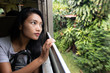 © milkovasa - A young woman goes by train and looks out the window.