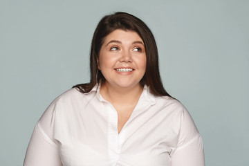 Wall Mural - Joy, happiness and positive human emotions. Beautiful attractive young woman employee with curvy body dressed in extra large white shirt smiling broadly, being happy excited with good news