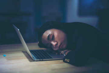 The young working women so tired from working hard business with clock and laptop concept