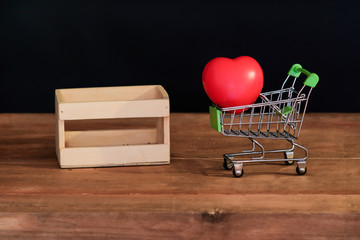 Wall Mural - Still life red heart on shopping cart on wood table .