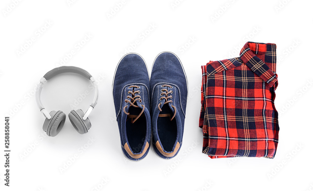 Shirt with sneakers and headphones on white background