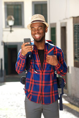 Wall Mural - smiling travel man with backpack and cellphone