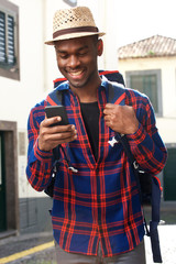 Wall Mural - smiling african american travel man with backpack and cellphone